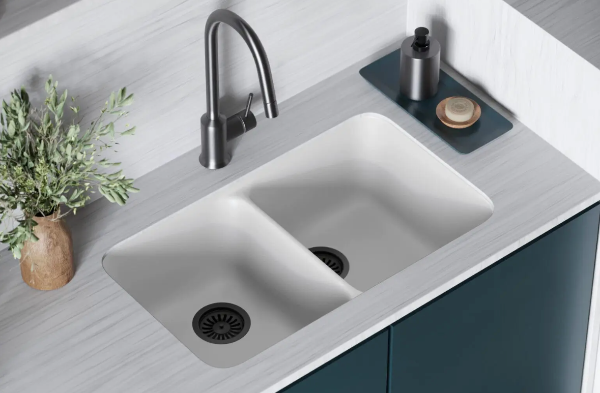 Modern white double-basin kitchen sink with black faucet, gray countertop, and small decor items