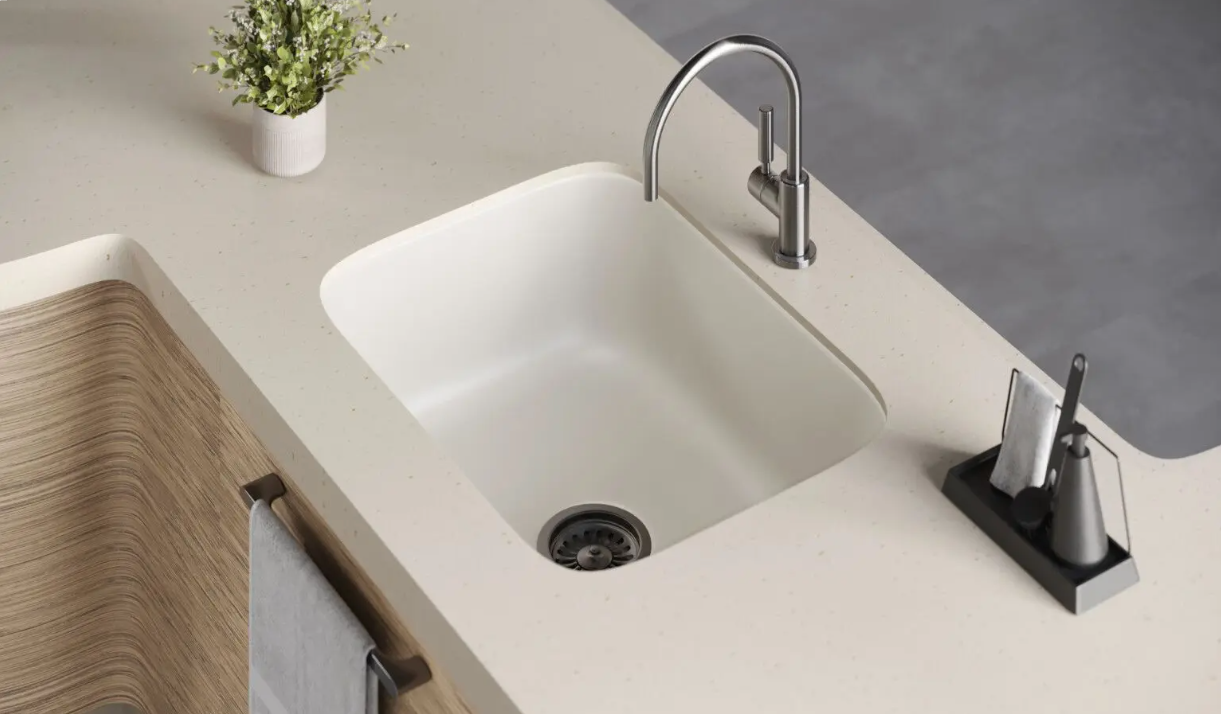 Modern bathroom sink with chrome faucet, soap dispenser, and small plant on a light countertop