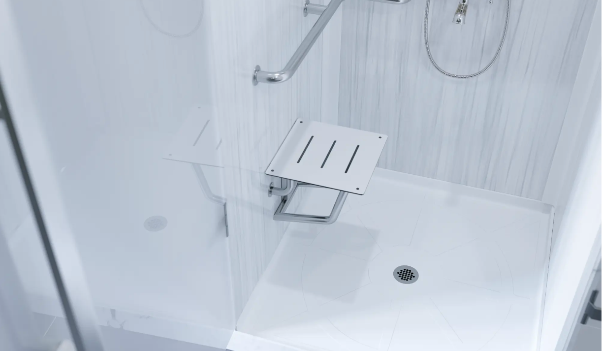 White shower stall with built-in bench, grab bar, handheld shower, and floor drain.