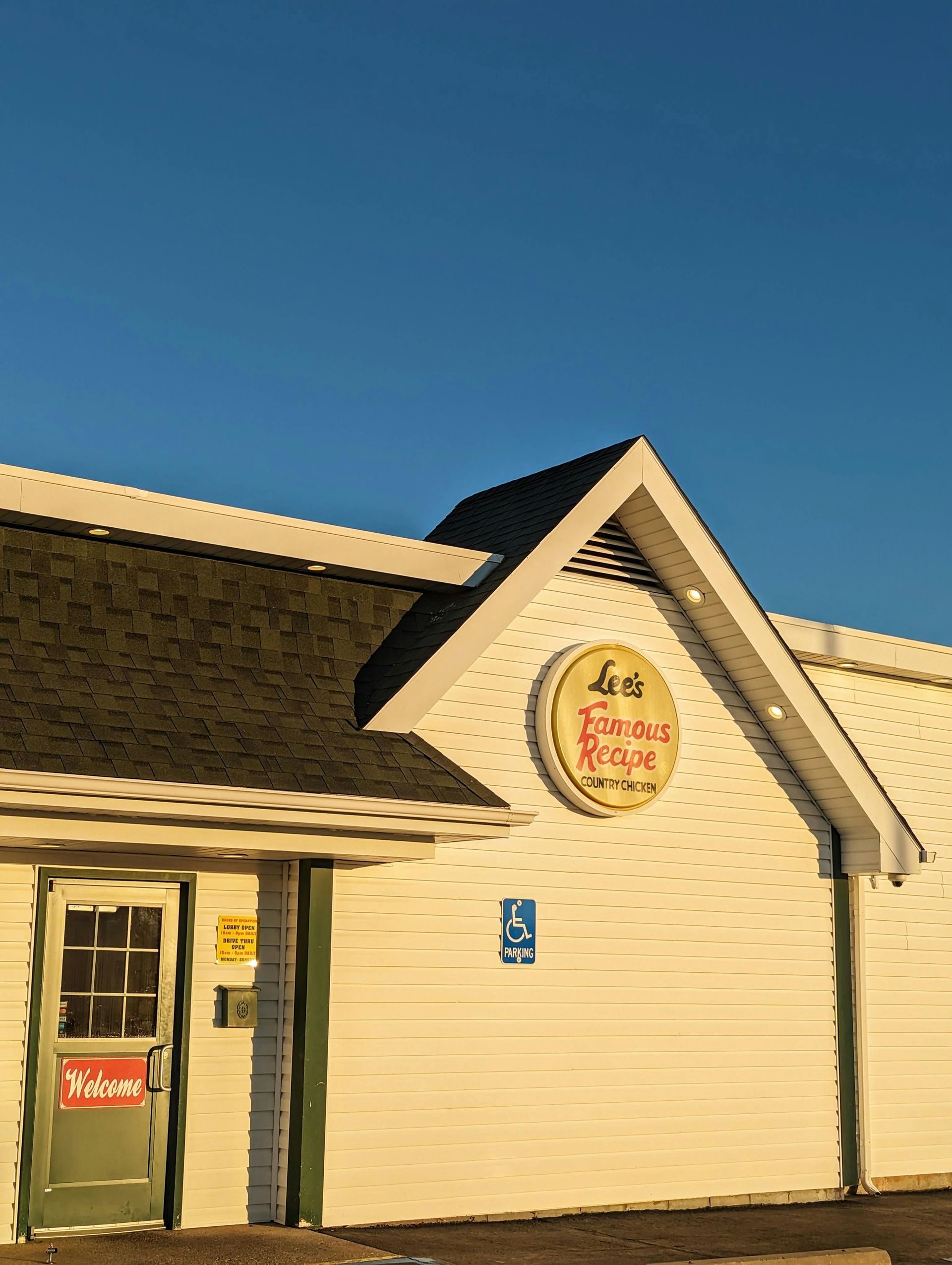 White building with dark roof, sign
