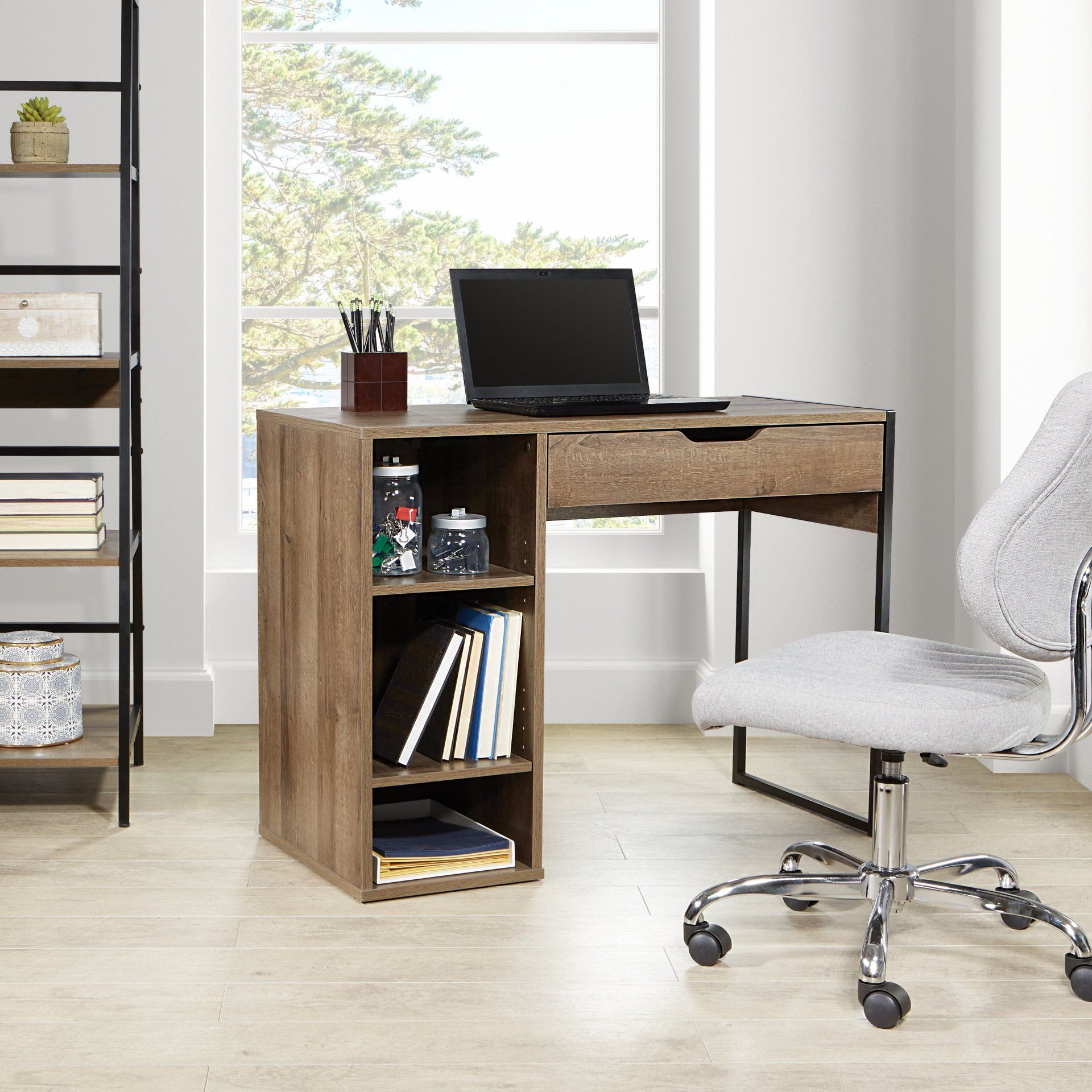 A desk with a laptop and a chair in a room