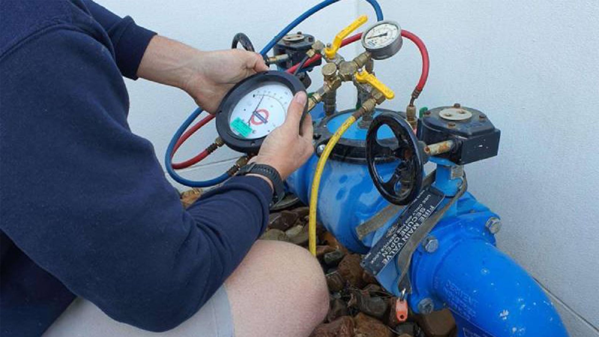 A person is turning a valve on a pipe.