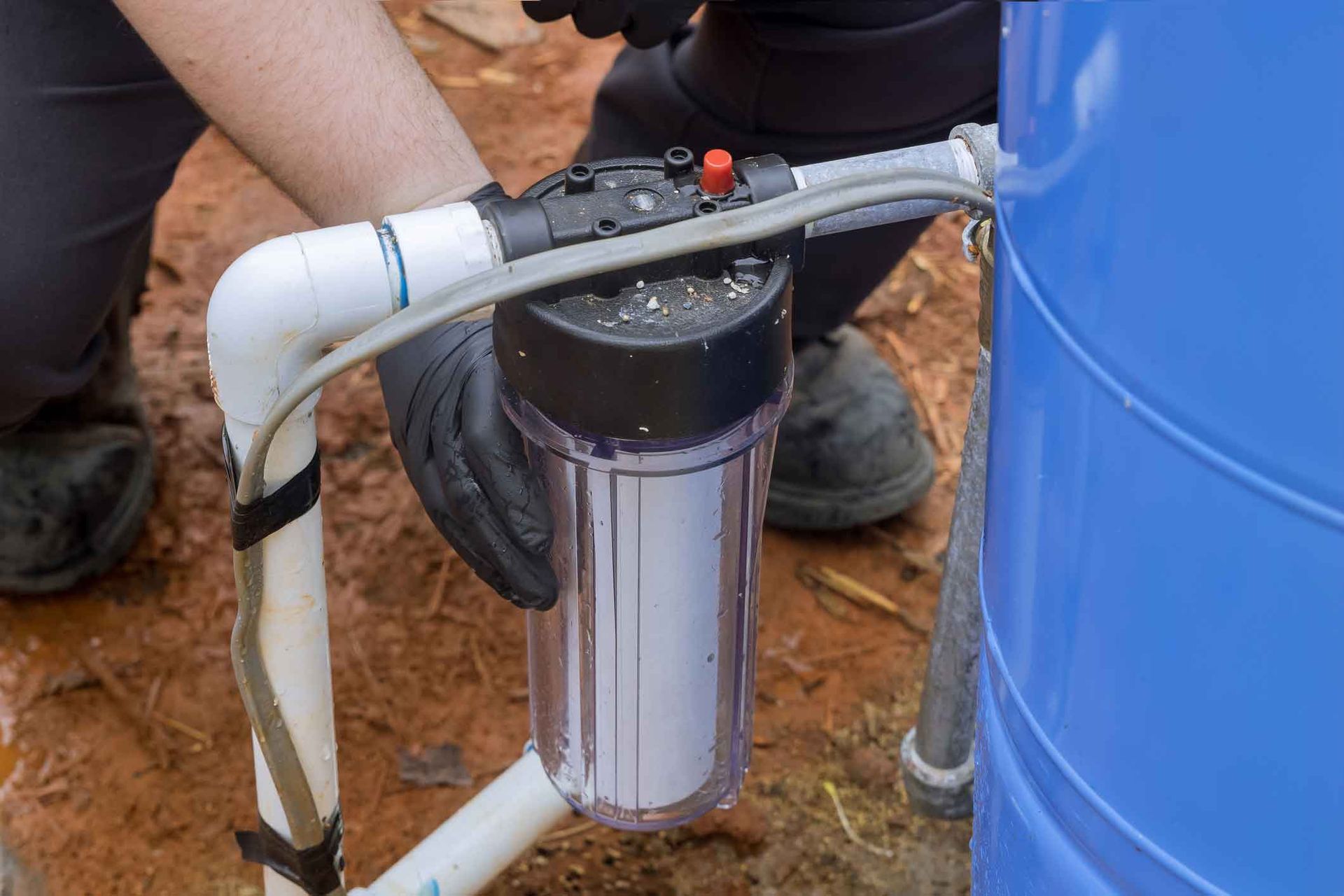 A person is installing a water filter into a water tank.