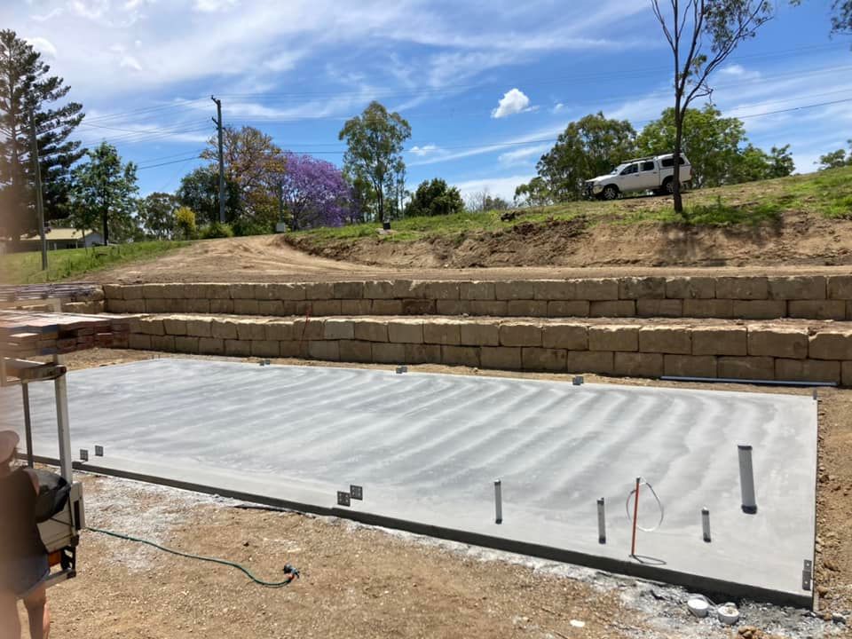 A Large Concrete Slab is Sitting on Top of a Dirt Field — Crete to Coast Concreting in Tamborine, QLD
