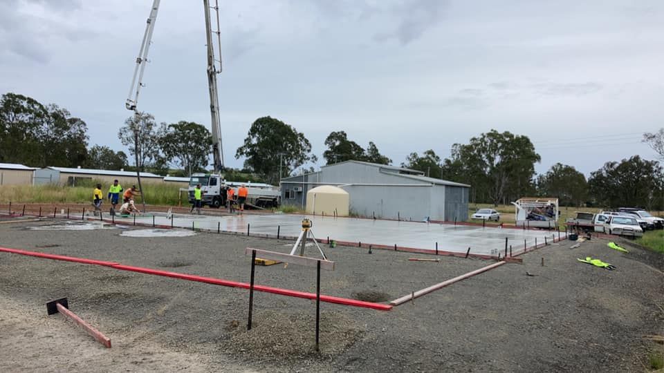 A Concrete Pump is Being Used to Pour Concrete on a Construction Site — Crete to Coast Concreting in Logan, QLD