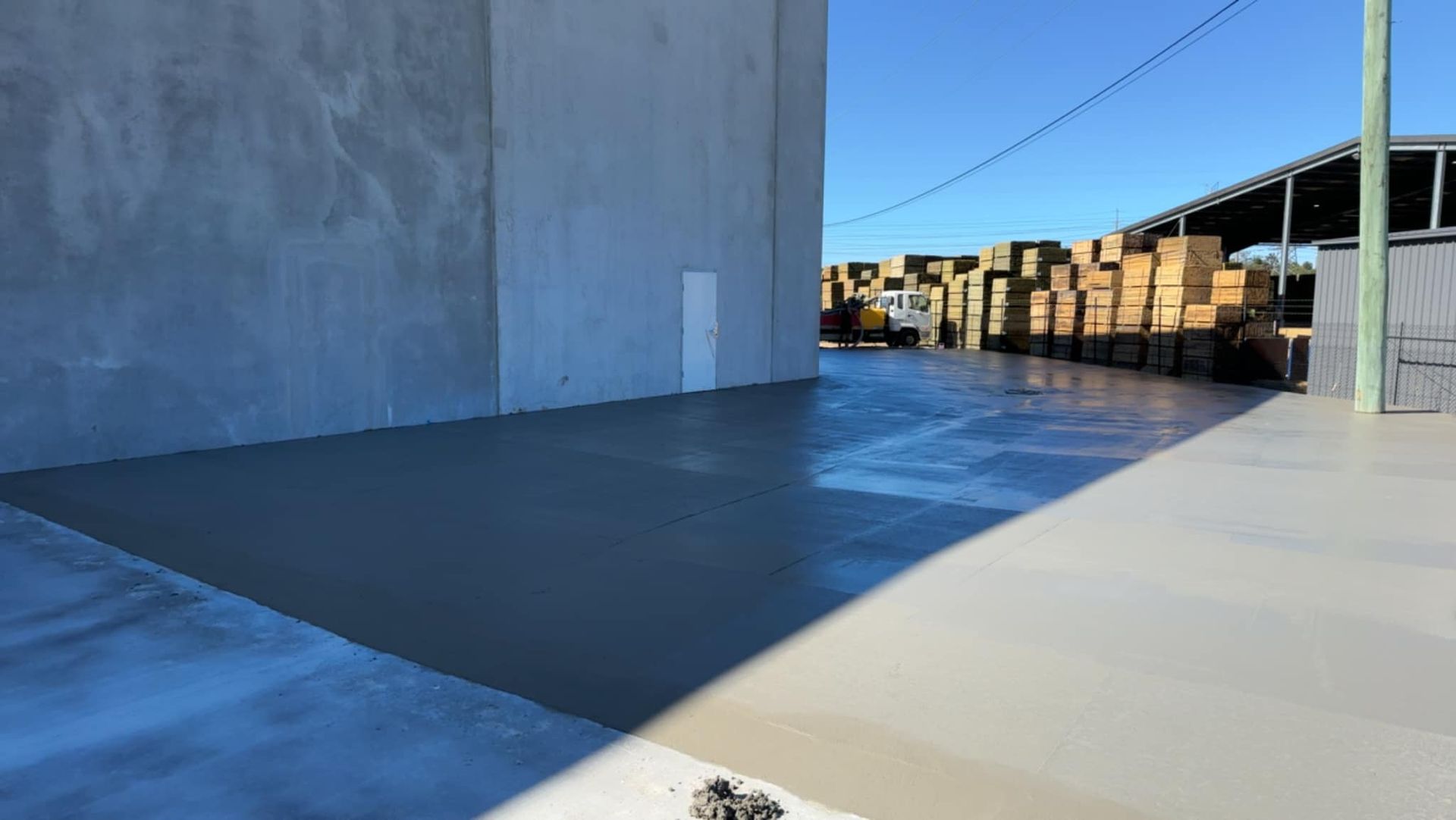 A Concrete Driveway in Front of a Building With a Lot of Boxes in the Background — Crete to Coast Concreting in Canungra, QLD