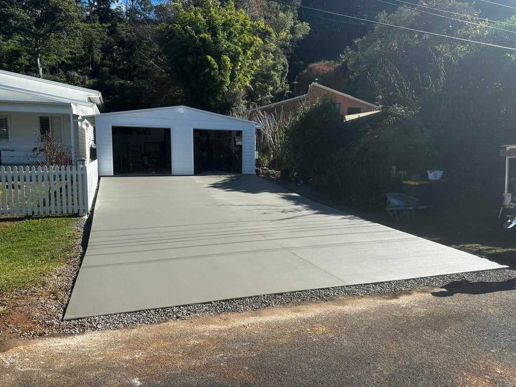 A Concrete Driveway is Being Built in Front of a House — Crete to Coast Concreting in Coomera, QLD