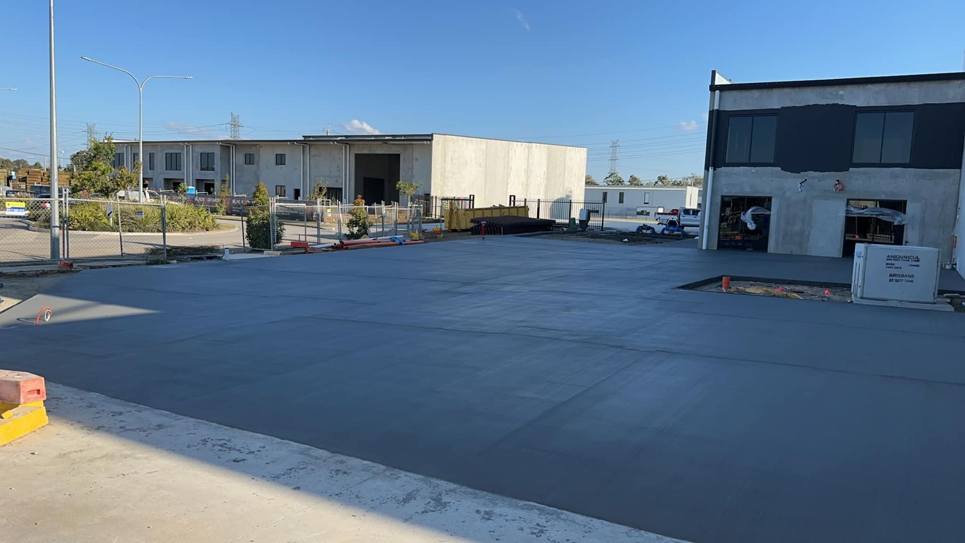 A Concrete Driveway is Being Built in Front of a Building — Crete to Coast Concreting in Coomera, QLD