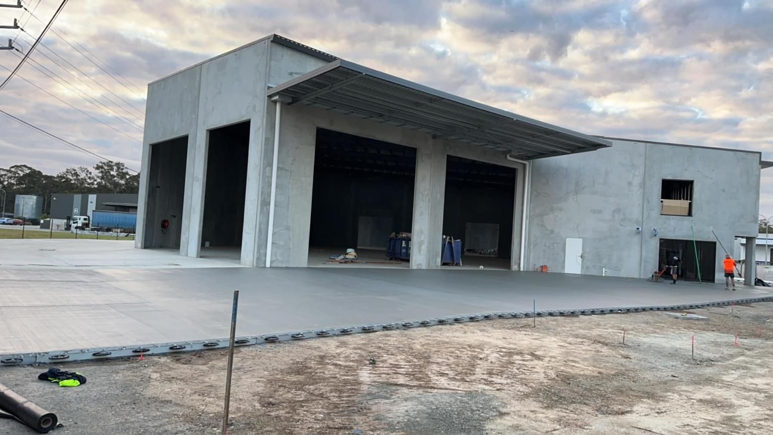 A Large Concrete Building With a Lot of Doors is Being Built— Crete to Coast Concreting in Tamborine, QLD