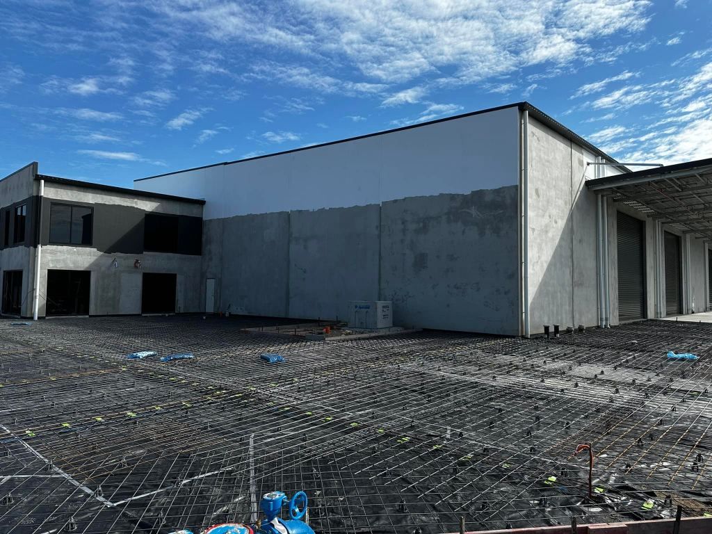 A Large Building is Being Built in the Middle of a Dirt Field — Crete to Coast Concreting in Tamborine Mountain, QLD