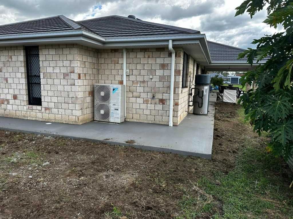 A Brick House With Two Air Conditioners on the Side of It — Crete to Coast Concreting in Canungra, QLD