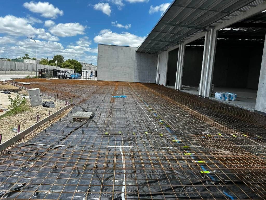 A Concrete Floor is Being Built in Front of a Building Under Construction — Crete to Coast Concreting in Browns Plains, QLD