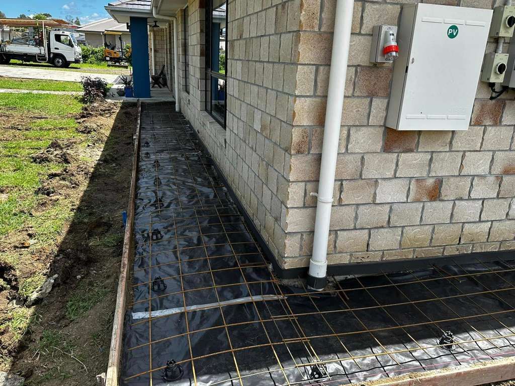 A Brick House With a White Roof and a Porch — Crete to Coast Concreting in Jimboomba, QLD