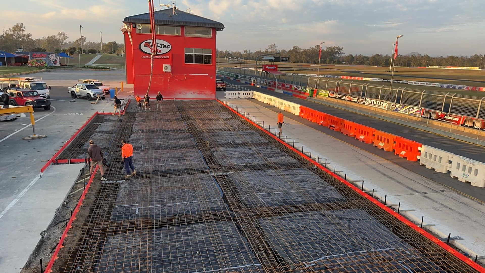 A Construction Site With a Container in the Foreground and a House in the Background — Crete to Coast Concreting in Tamborine, QLD