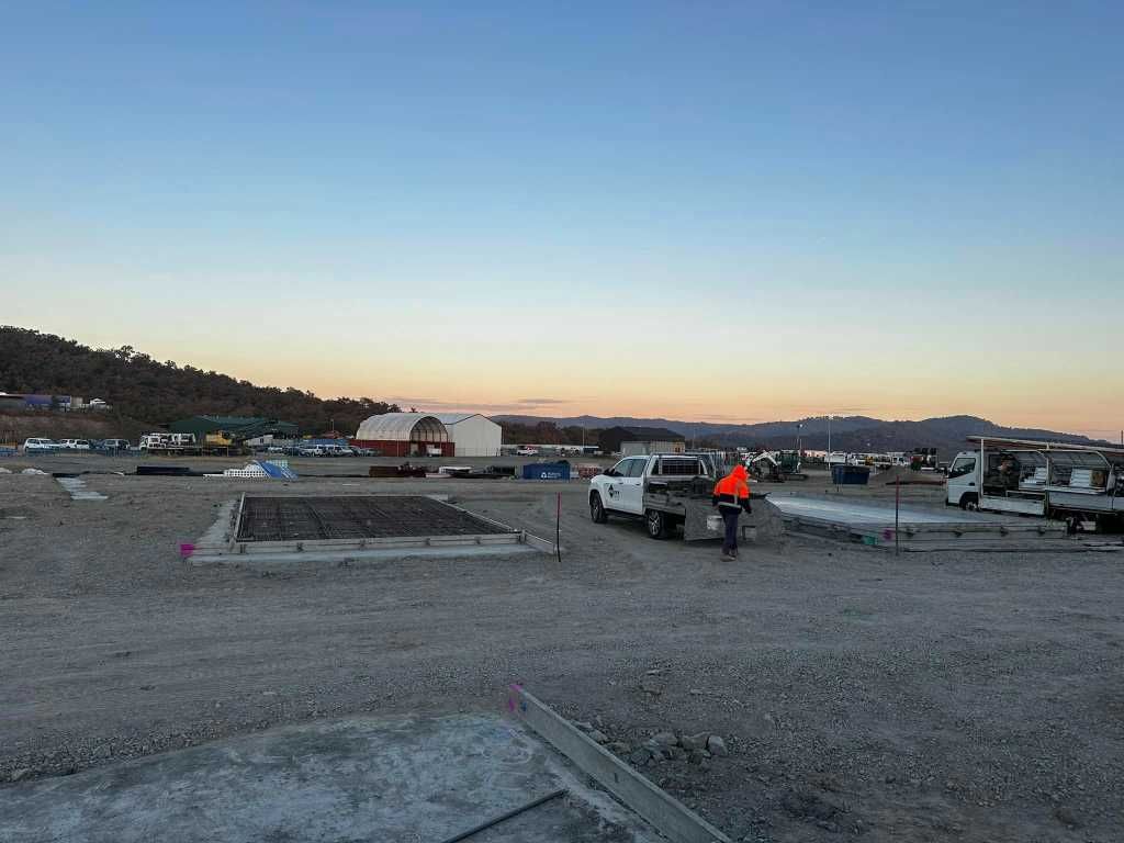 A Construction Site With a Lot of Trucks Parked in the Dirt — Crete to Coast Concreting in Browns Plains, QLD