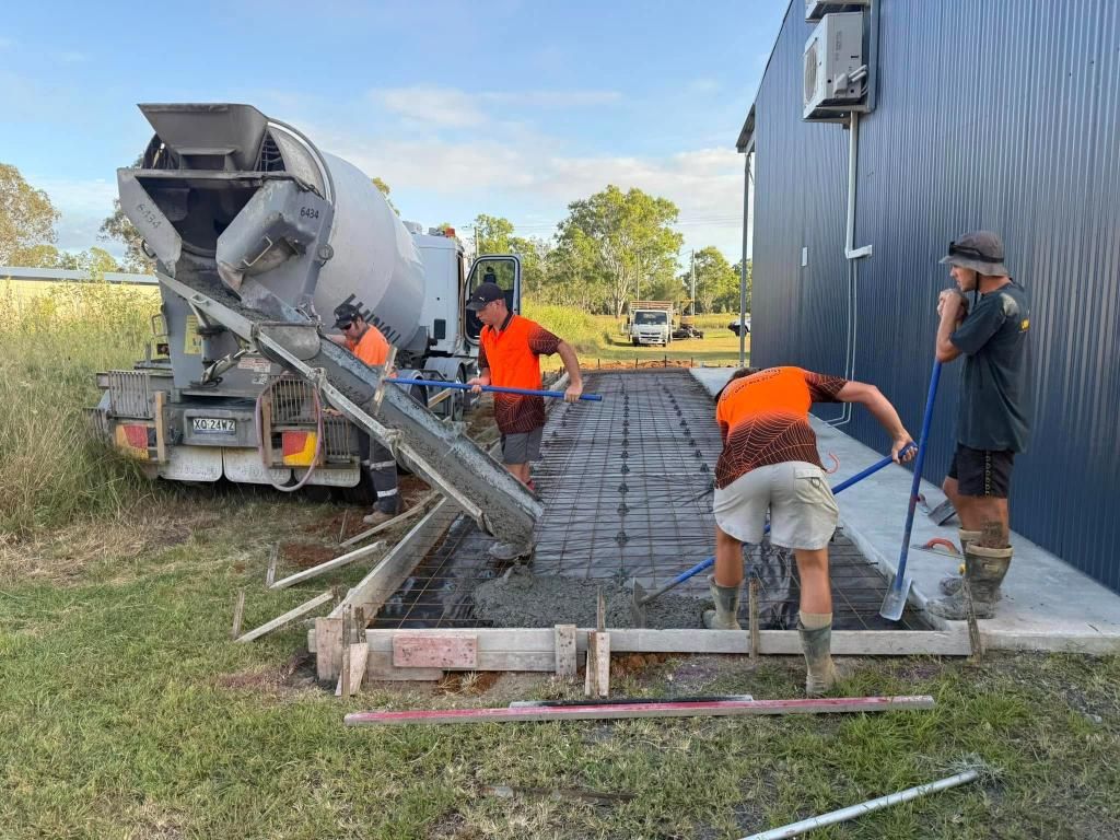 A Group of Construction Workers Are Working on a Concrete Driveway — Crete to Coast Concreting in Browns Plains, QLD
