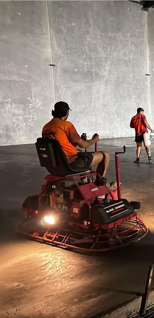 A Man is Riding a Machine on a Concrete Floor — Crete to Coast Concreting in Tamborine, QLD