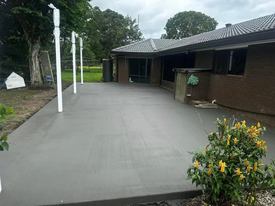 A Large Concrete Patio in Front of a Brick House — Crete to Coast Concreting in Logan, QLD