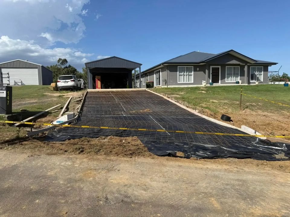 A Driveway is Being Built in Front of a House — Crete to Coast Concreting in Logan, QLD