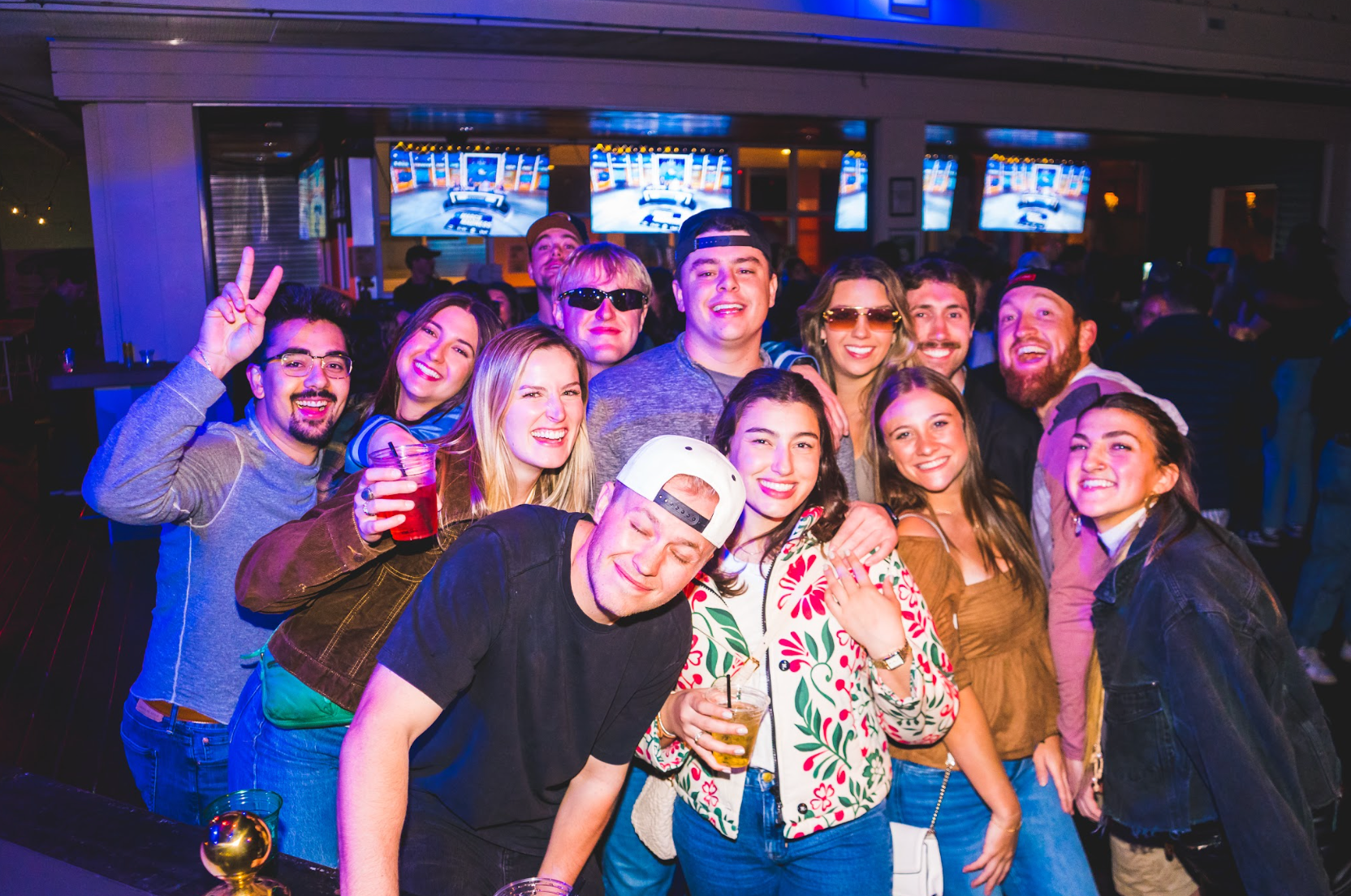 A group of people are posing for a picture at el patio, a night club and bar located in downtown denver colorado.
