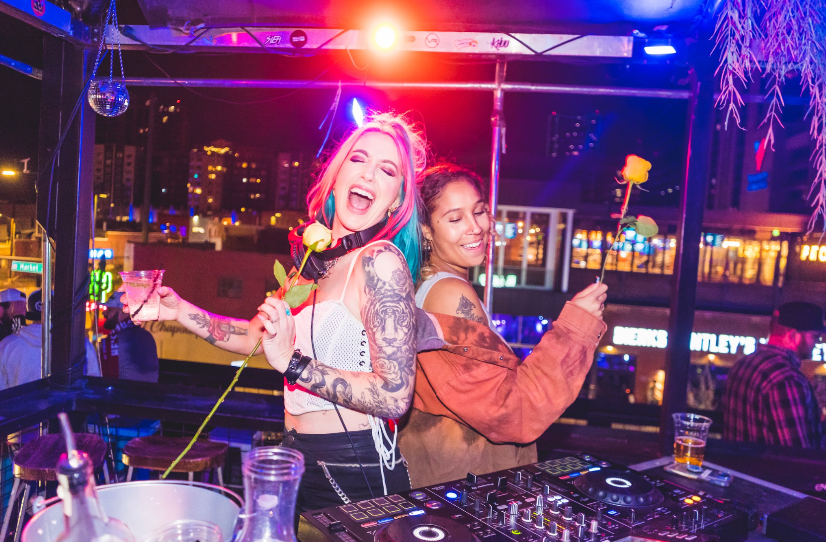 Two women are standing next to each other at el patio, a night club and bar located in downtown denver colorado.