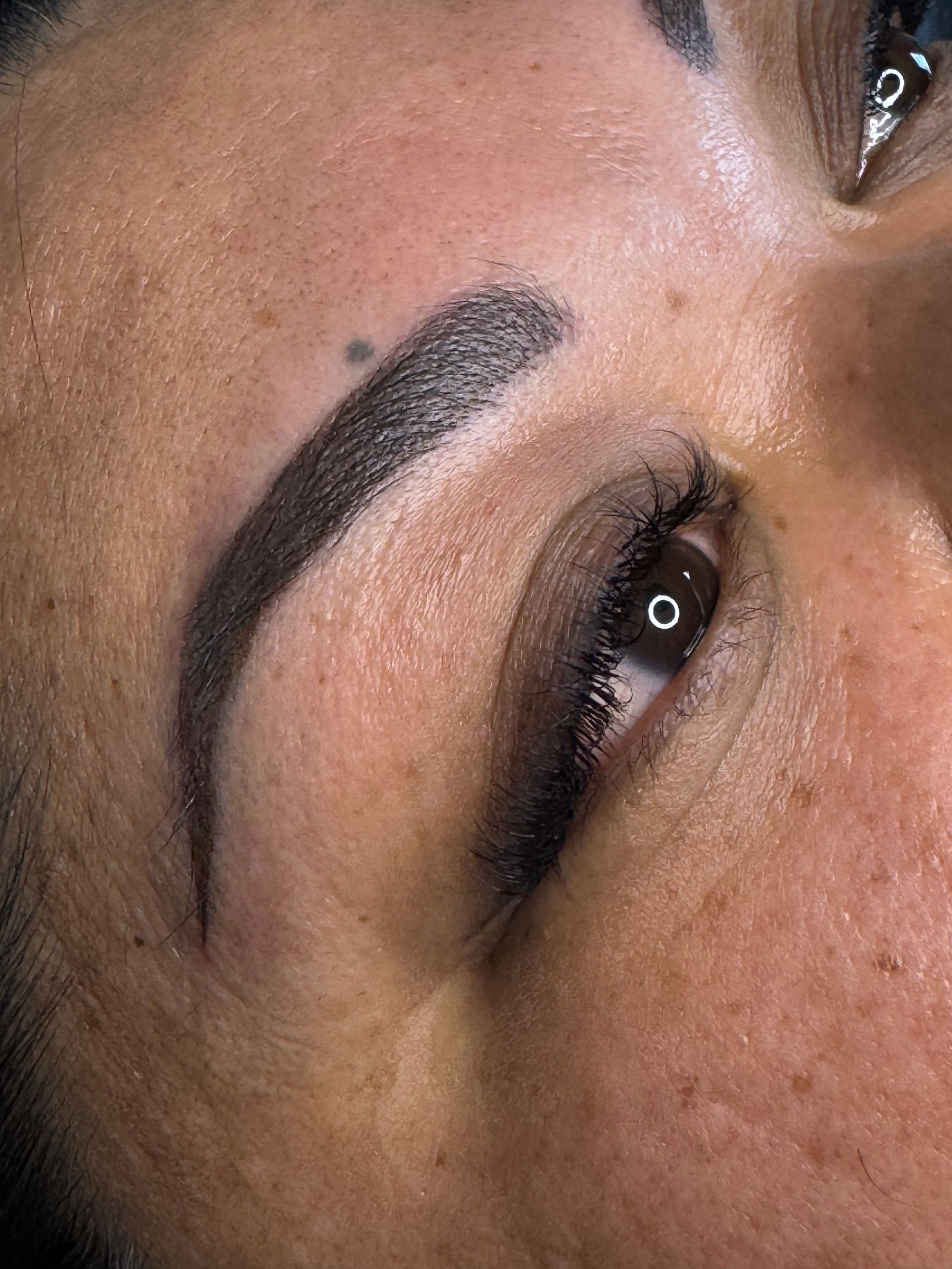 Close-up of an eye with a dark, arched eyebrow and eyeliner makeup