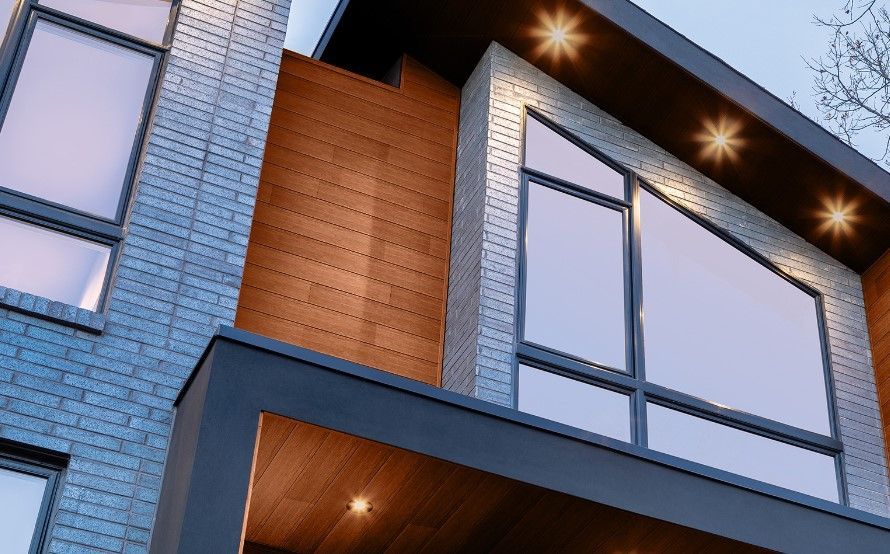 A modern house with a lot of windows and a balcony.