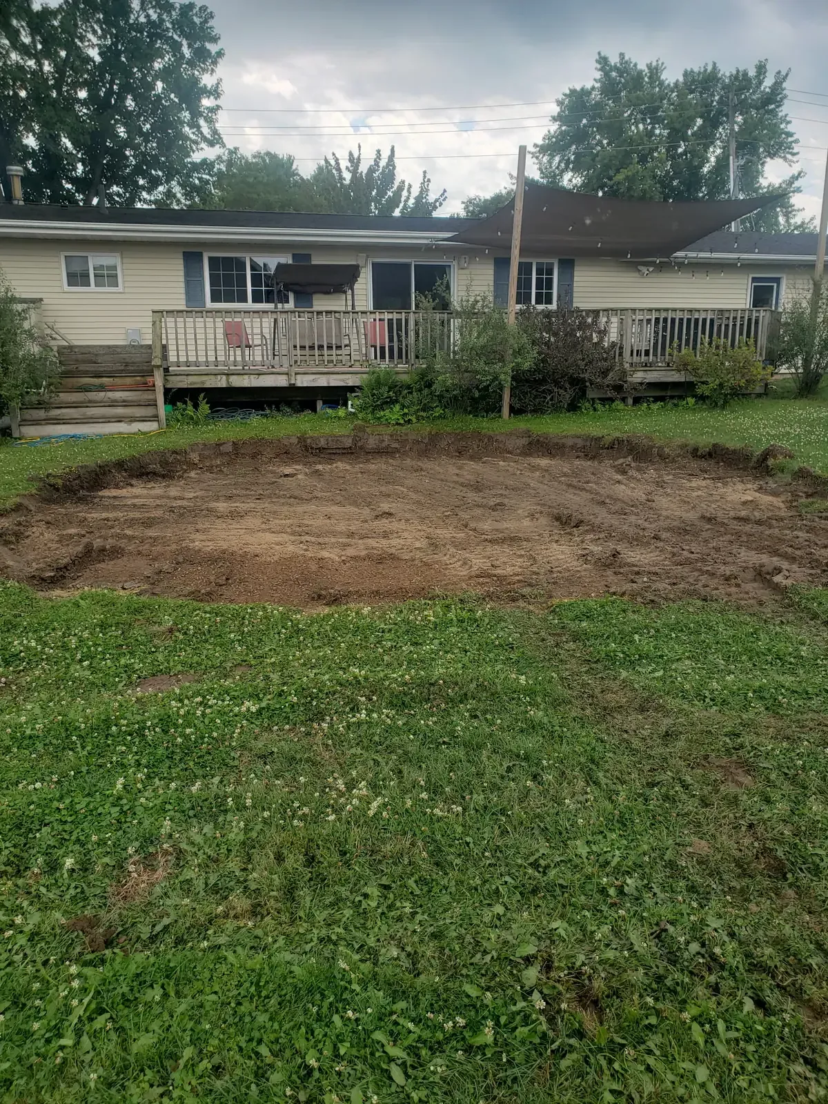 Bare, leveled circle of soil left after removing an above-ground pool pad behind a ranch home near Marshfield, WI