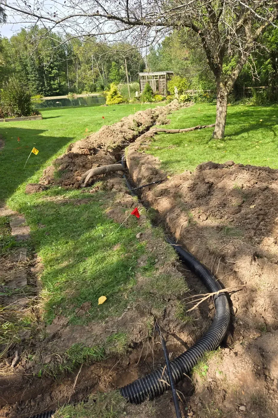 Corrugated drain tile laid in an open trench across a residential yard in Marshfield, WI