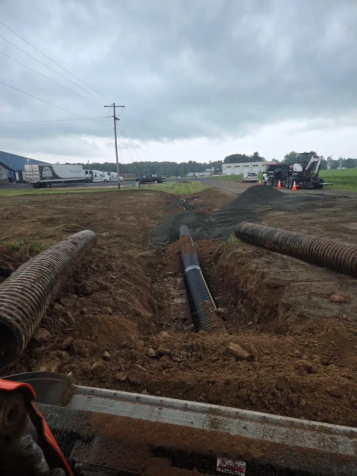 Culvert pipe laid in a trench with gravel staged alongside during a 120-foot run in Curtiss, WI – ERE Excavation