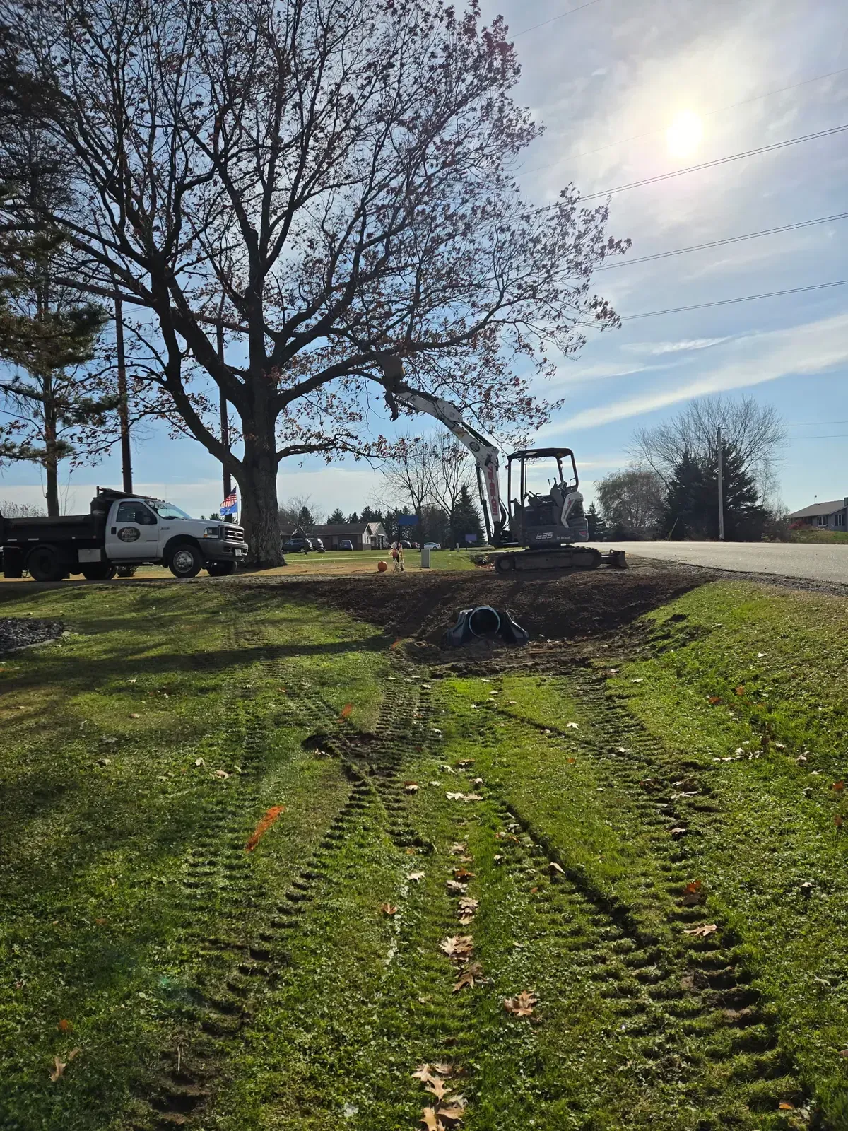 Completed driveway culvert replacement with regraded ditch, mini excavator and ERE dump truck on site in Marshfield, WI