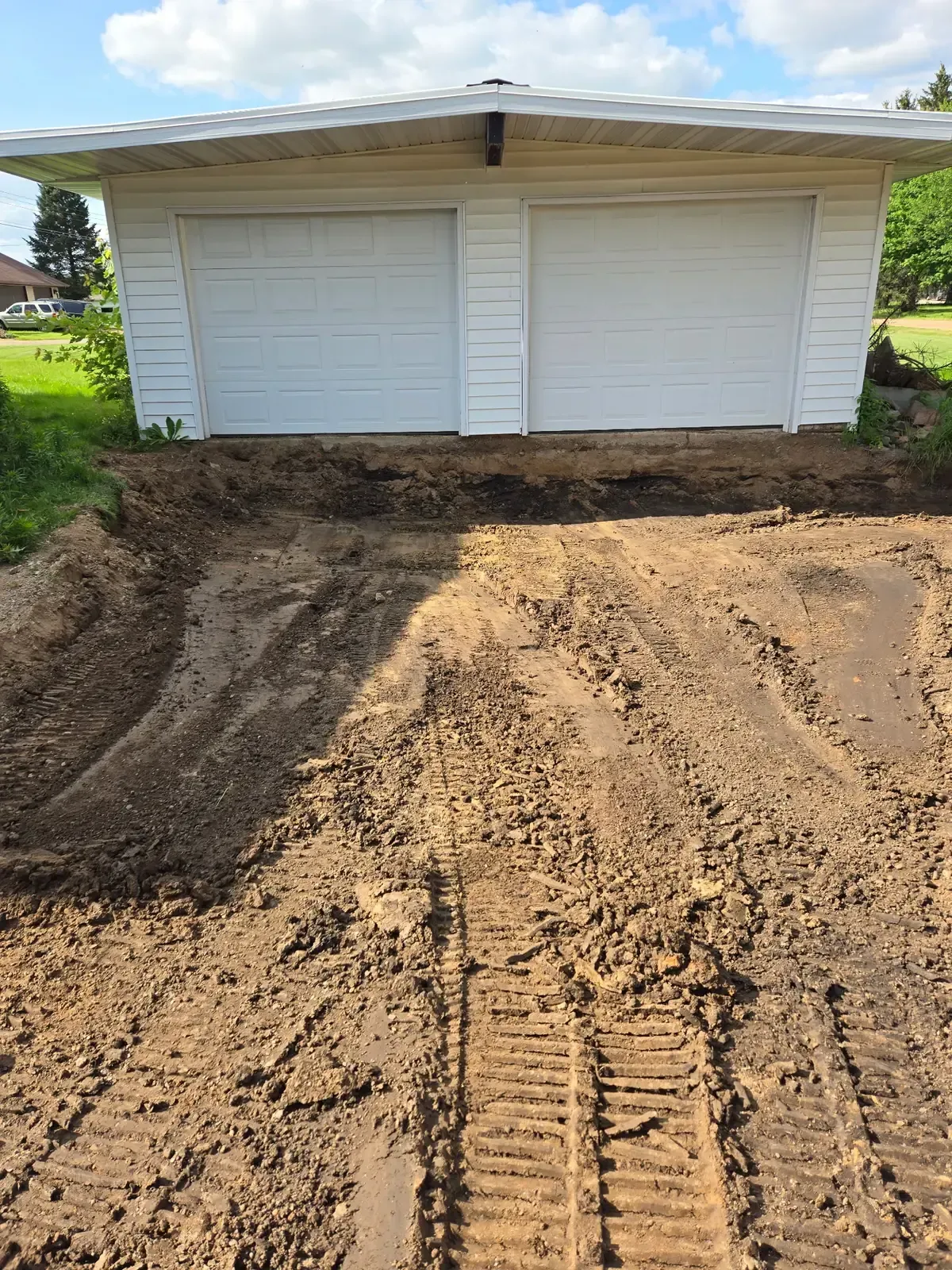 Old driveway removed and subgrade excavated in front of a two-car garage in Colby, WI