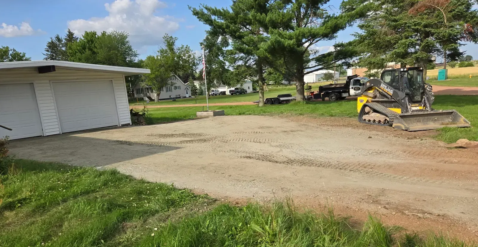 Completed driveway rebuild at a two-car garage with ERE equipment on site in Colby, WI.