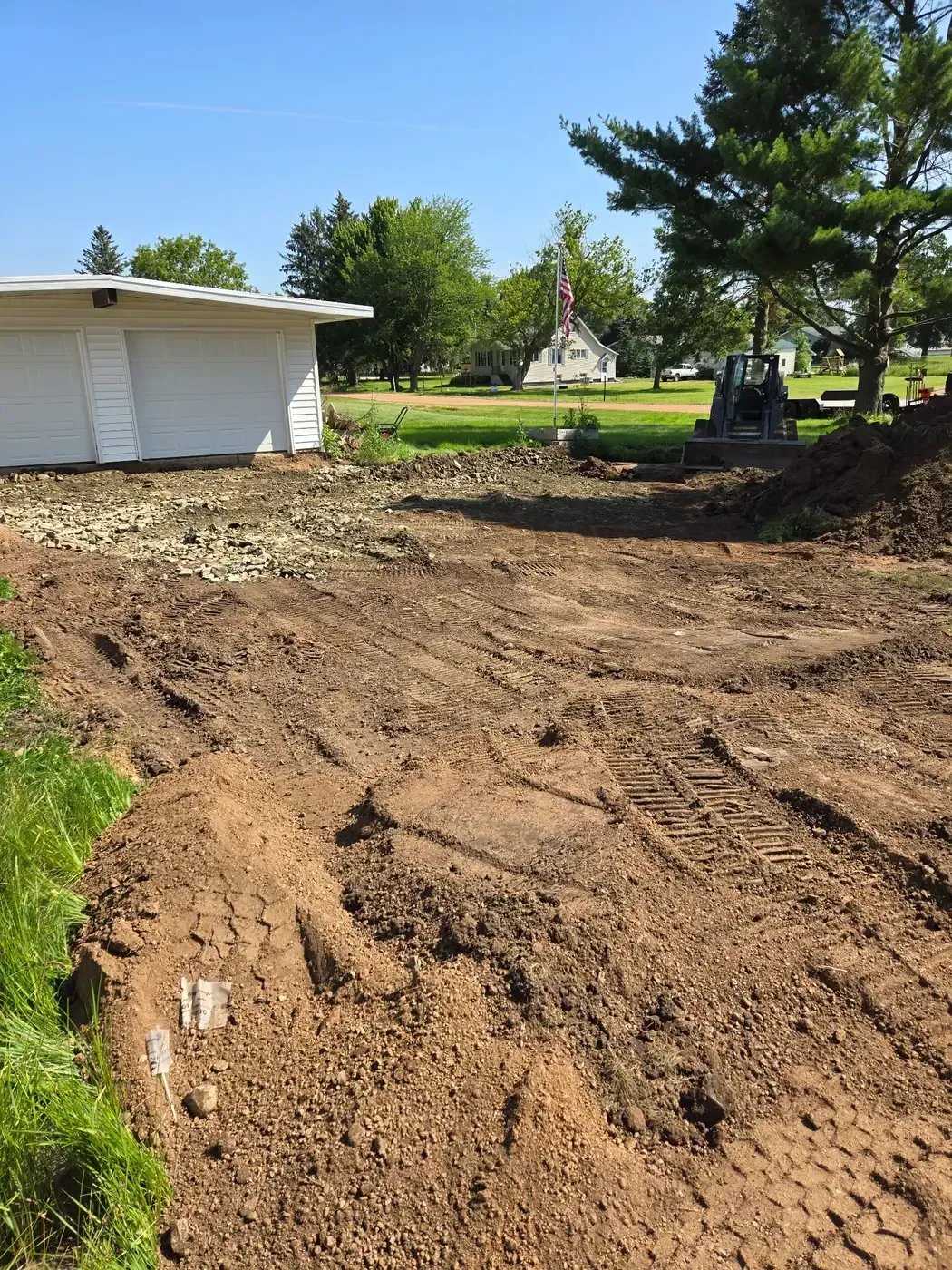 Driveway excavation with a compact track loader removing old concrete and soil in Colby, WI