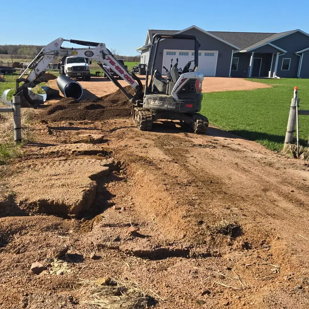 Failed driveway culvert with water backed up in the ditch during an emergency replacement in Marshfield, WI