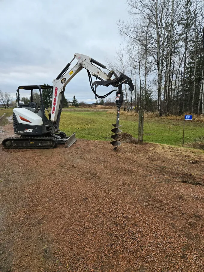 Skid steer auger drilling a fence post hole – ERE Excavation, Central Wisconsin