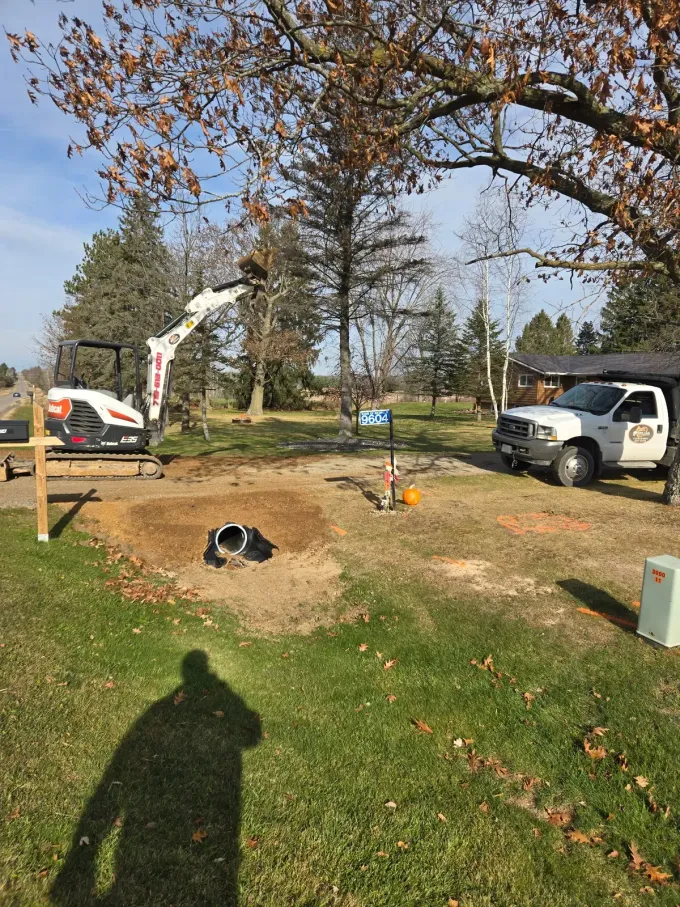 Mini excavator installing a culvert pipe at a driveway entrance – ERE Excavation, Central Wisconsin