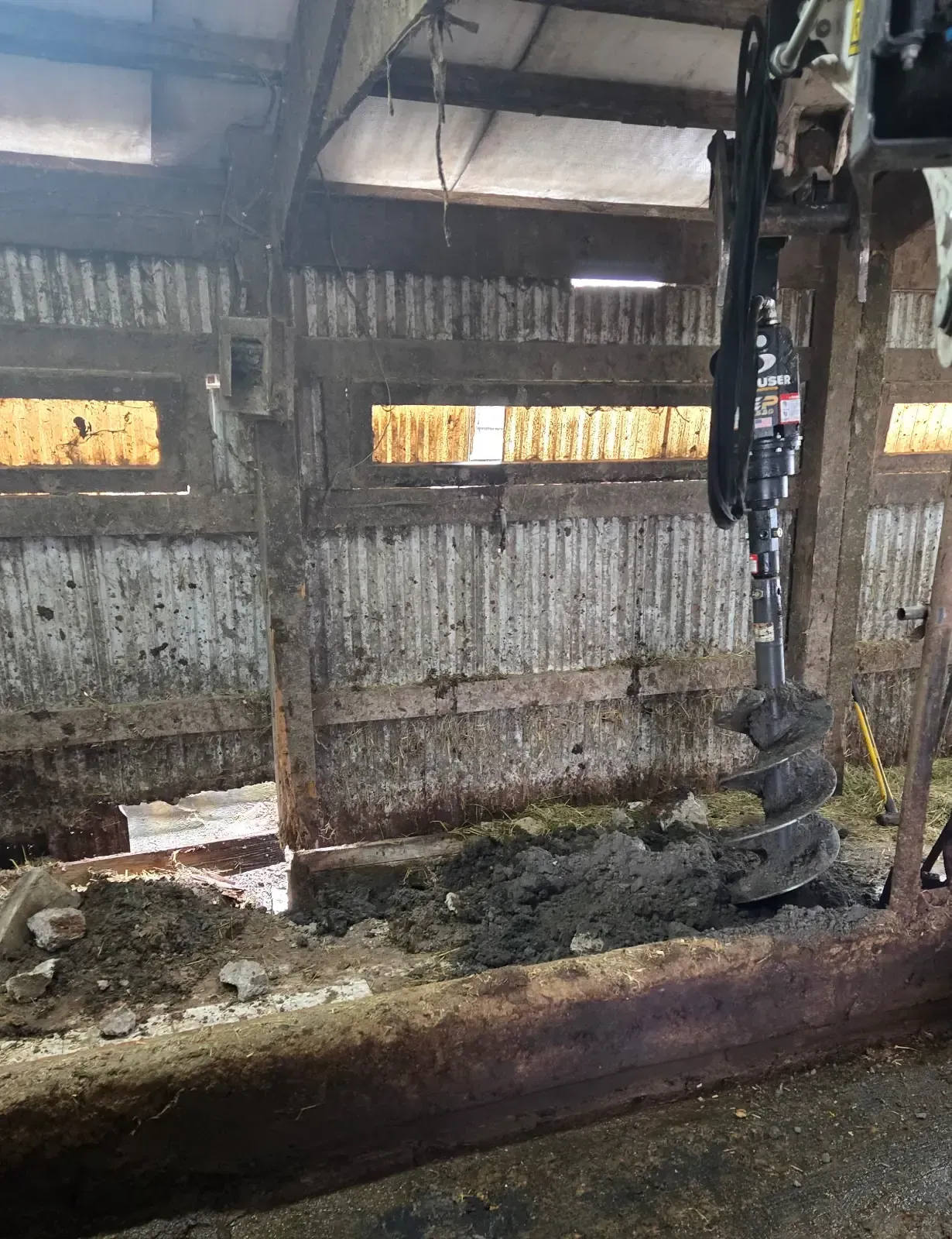 Mini excavator with auger attachment replacing rotted barn posts in Colby, WI