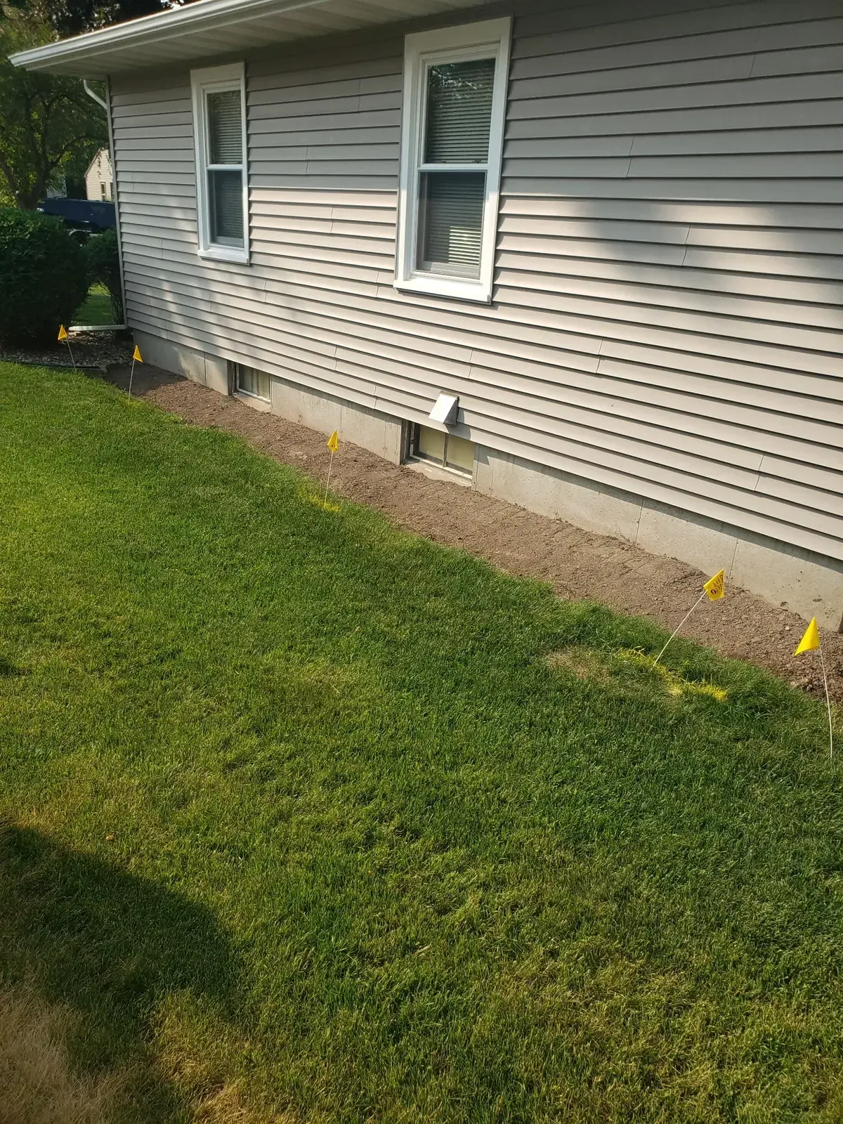 Completed French drain with regraded soil along the foundation and lawn intact in Marshfield, WI