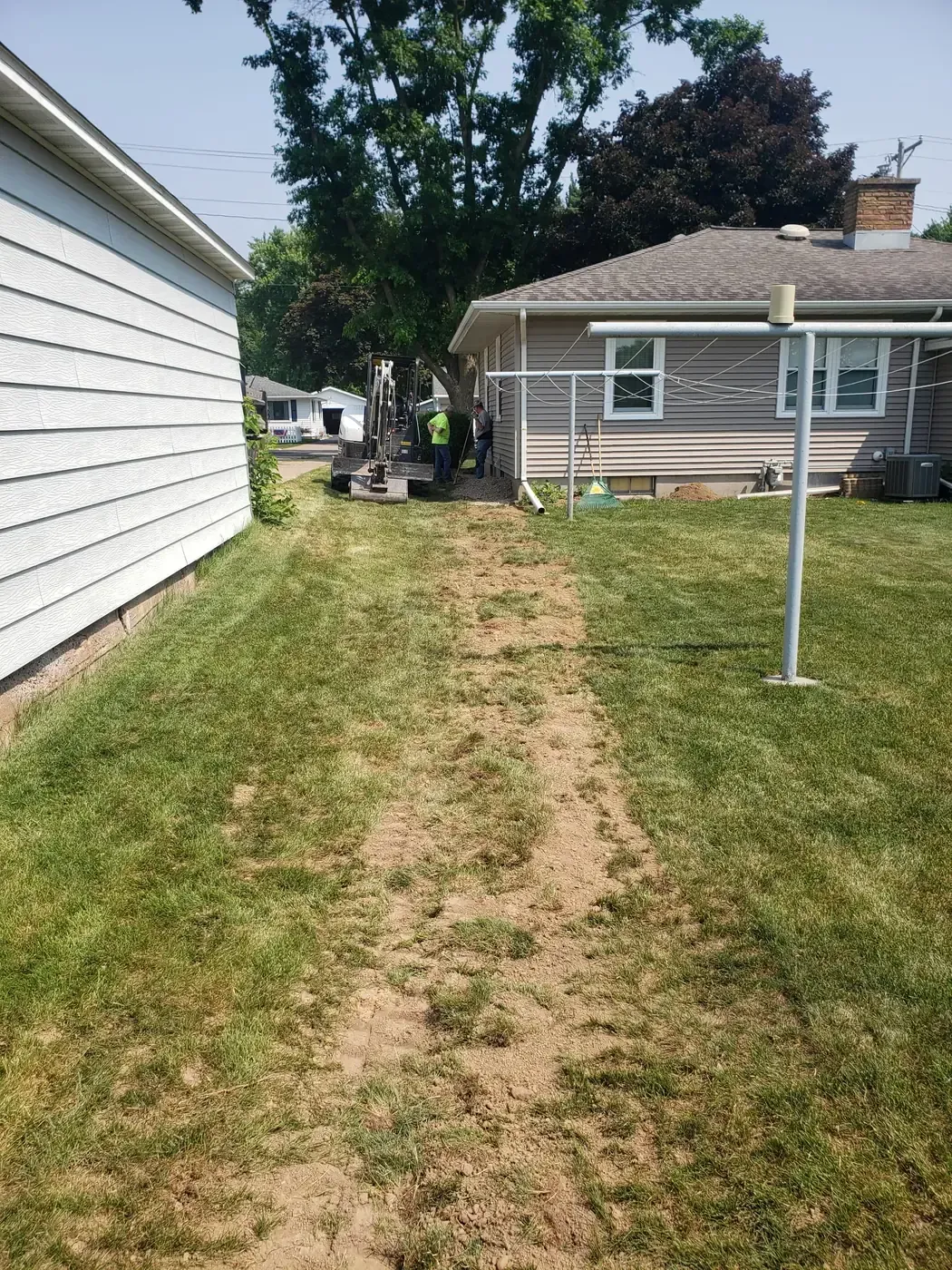 French drain discharge trench backfilled and leveled across a residential lawn in Marshfield, WI