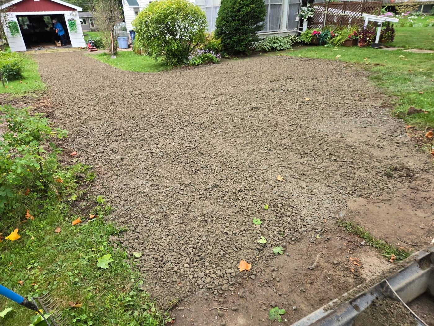 Freshly installed and leveled gravel driveway curving to a detached garage after replacement of the old concrete in Stratford, WI