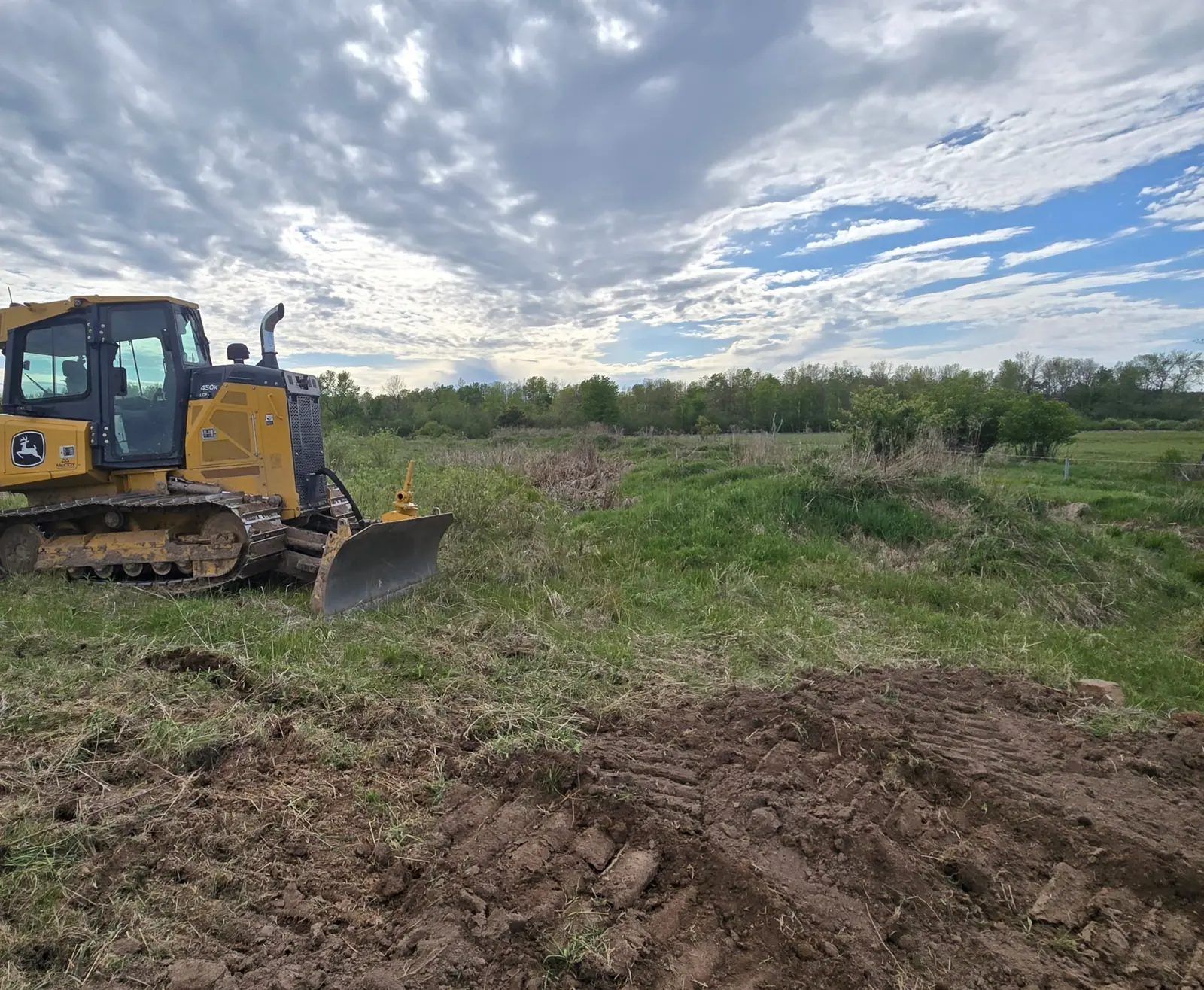 Bulldozer starting work on an overgrown earthen bank in a pasture during an NRCS conservation project near Marshfield, WI