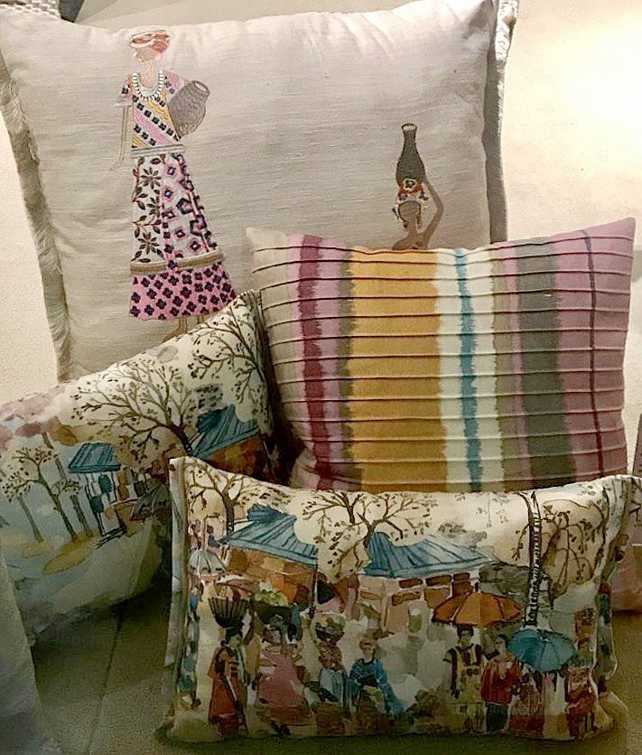 Cuscini decorativi con motivi colorati e dettagli a righe su una sedia o un divano