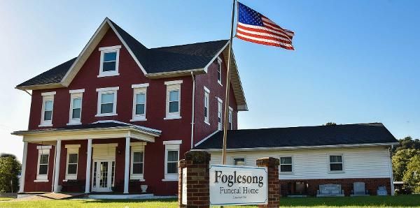 Single-story building with an American flag flying outside and a landscaped front entrance.