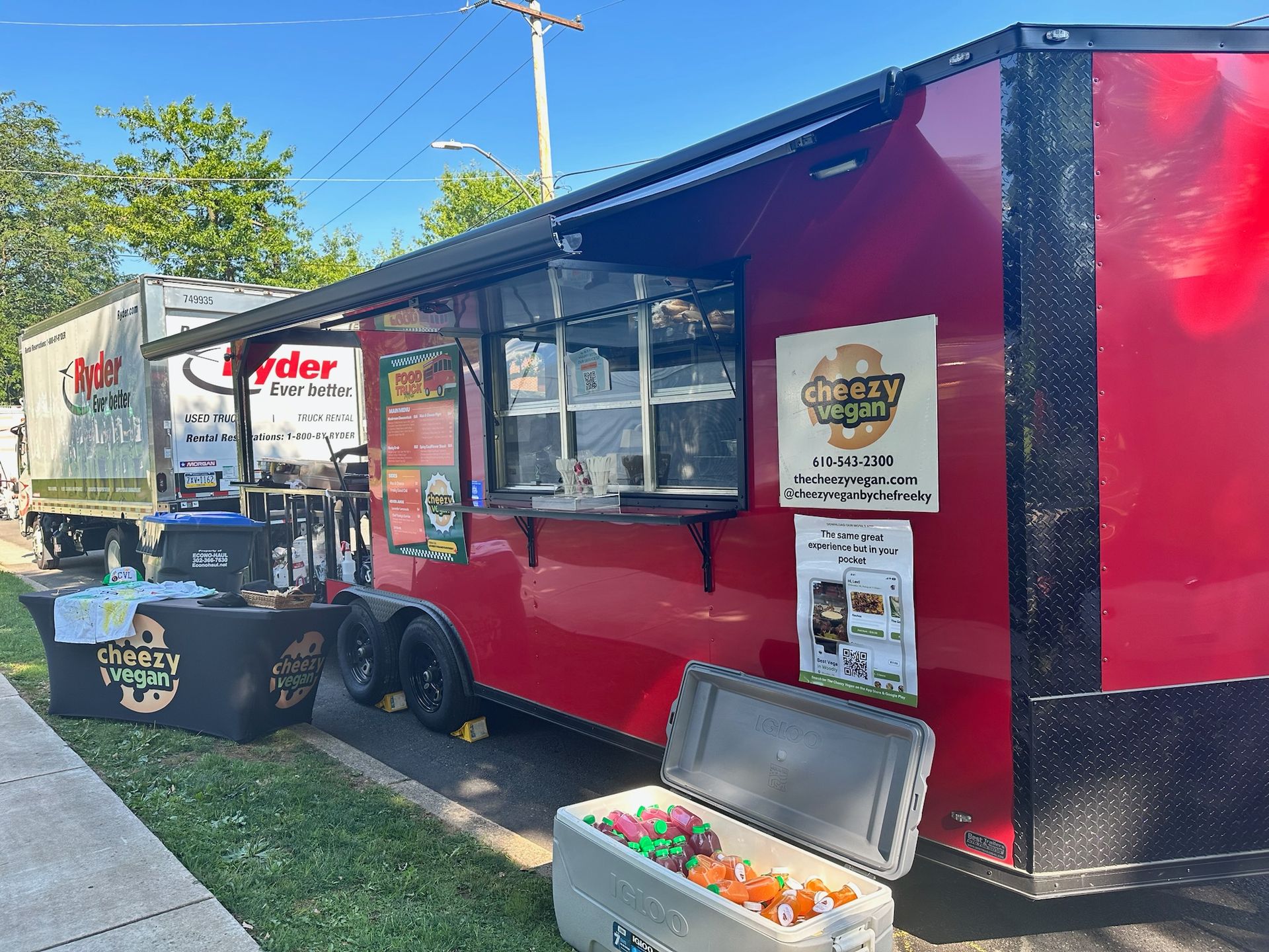 A bright red food trailer parked outdoors, featuring the 