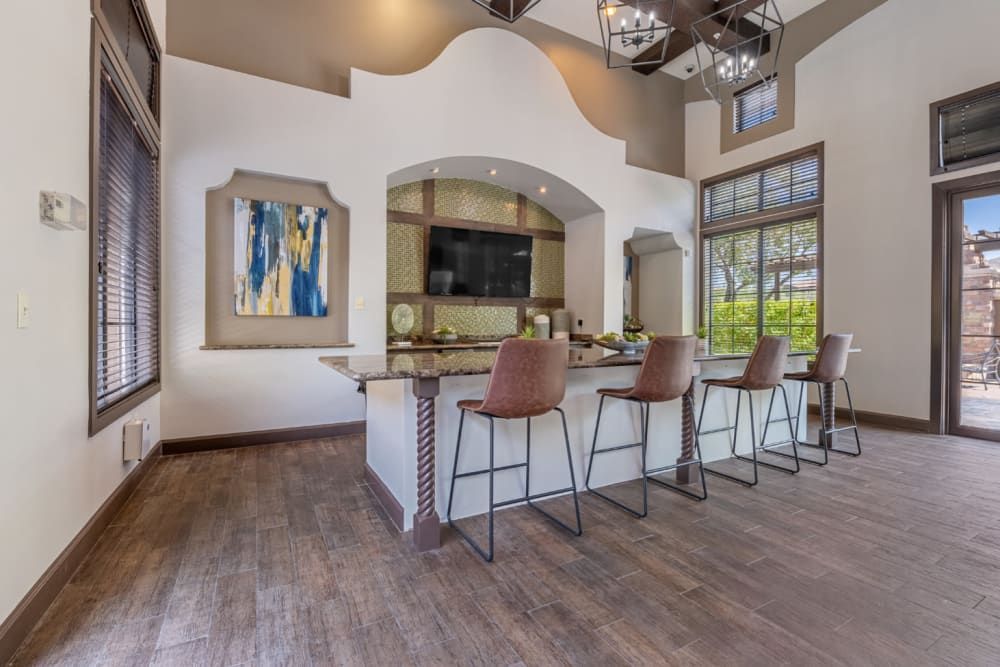 Modern community kitchen with island seating, pendant lights, and large windows in a bright open-concept home