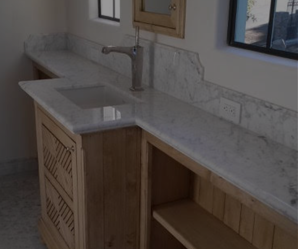 Bathroom vanity with marble countertop, wooden cabinets, and a silver faucet.