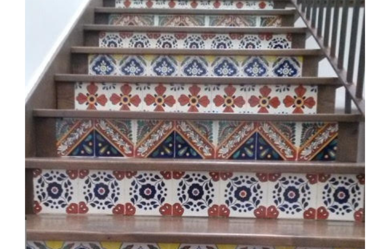 Staircase with colorful decorative tiles, various patterns in red, blue, and yellow, wooden steps and railings.