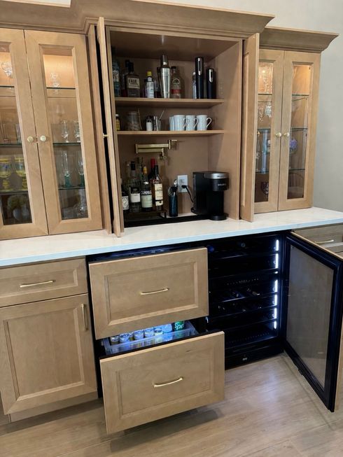 Kitchen hutch bar cabinet with open shelves, glass doors, wine bottles, and drawers pulled open