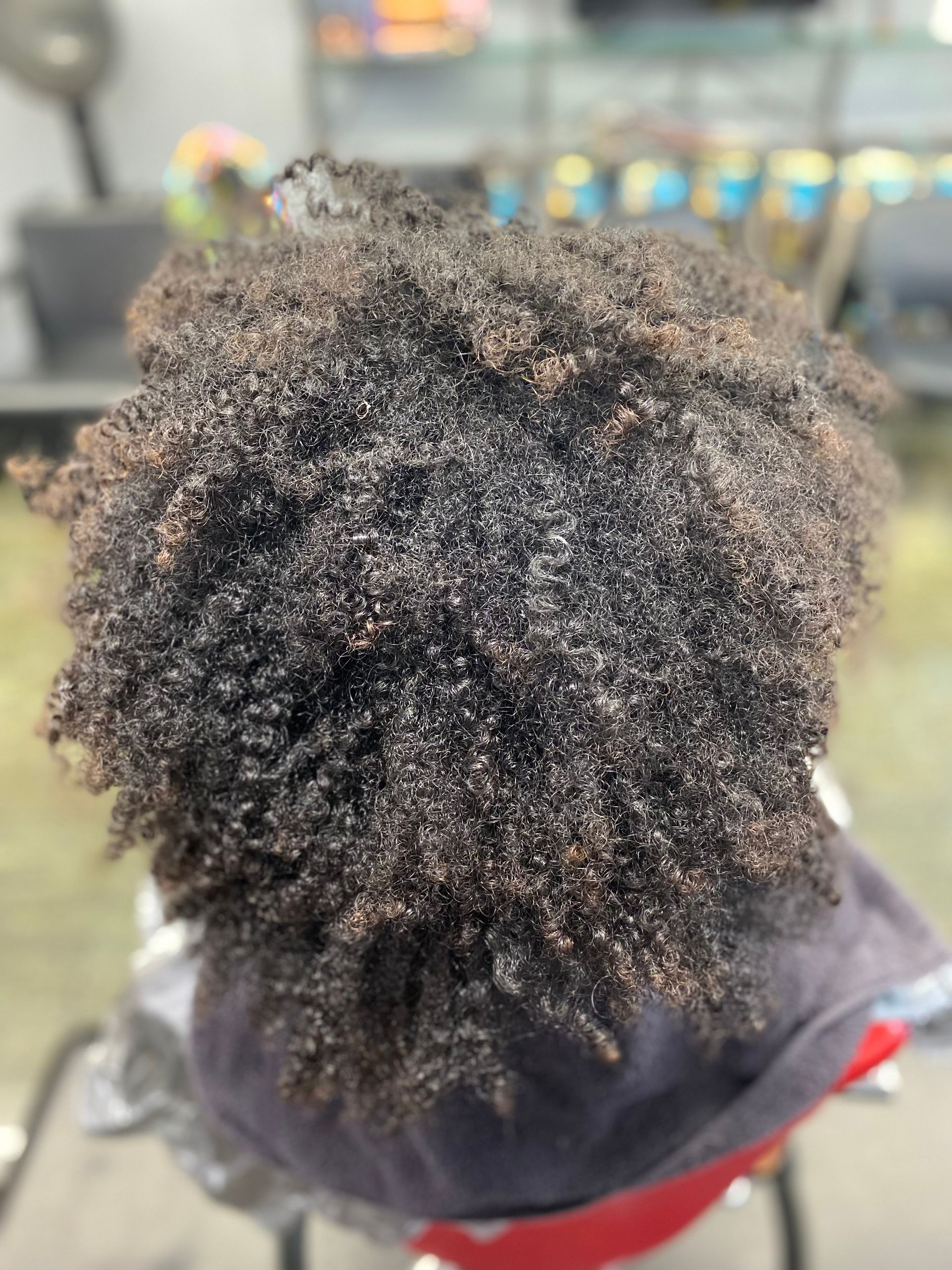 A close up of a person 's hair sitting on a chair.